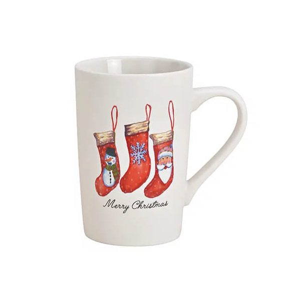 Tasse en porcelaine Merry Christmas avec chaussettes de Noël sur lesquelles figurent une étoile, le Père Noël et un bonhomme de neige, capacité de 350ml.


