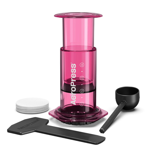 AeroPress Coffee Maker Clear Pink complete set with chamber plunger scoop stirrer and paper filters on white background