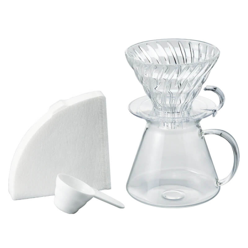 Hario V60 Glass Brewing Kit con dripper, server, filtri di carta e misurino su sfondo chiaro.