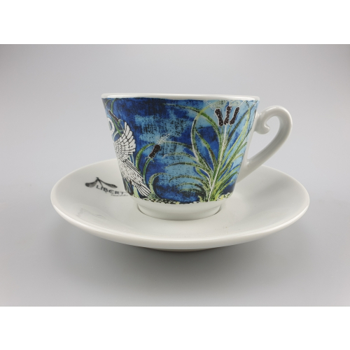 Liberty Kaffeetasse in Blau mit einem feinen Vogel- und Pflanzenmuster, platziert auf einer passenden Untertasse, vereint Natur und Kunst