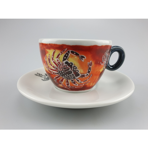 Selva Antica coffee cup in orange, decorated with a unique pattern and a crab, on a matching white porcelain saucer.
