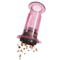 AeroPress Coffee Maker Clear Pink lors du remplissage de café moulu dans la chambre d'infusion transparente