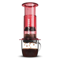 AeroPress Coffee Maker - Clear Red en train de préparer du café dans une tasse.


