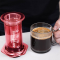 AeroPress Coffee Maker - Clear Red avec une tasse de café fraîchement préparé.



