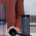 AeroPress Ersatzgummidichtung – AeroPress Kaffeezubereiter mit Vorratsbehälter und Messlöffel auf dem Tisch
