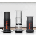 Trois machines à café AeroPress (Original, Go, Clear) équipées du couvercle filtrant pour différentes options d'infusion.



