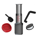 Machine à café de voyage AeroPress® Go avec accessoires : agitateur, cuillère doseuse, porte-filtre et couvercle – tout s’insère dans la tasse.



