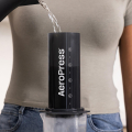 Versement d'eau dans une AeroPress Coffee & Espressomaker - XL posée sur une carafe transparente, avec une personne visible en arrière-plan.


