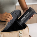 Une personne range une AeroPress Coffee & Espressomaker - XL dans un sac de voyage, parfait pour préparer du café en déplacement.


