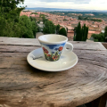 Tasse à espresso Aquarelli avec un motif de fleurs (coquelicots et bleuets) sur une table en bois dans un village italien.
