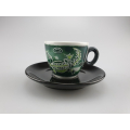 Selva Antica Espressotasse in Grün mit traditionellen Mustern und einer Eidechse, Made in Italy, präsentiert auf einer passenden schwarzen Untertasse
