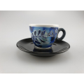 Künstlerisch gestaltete Selva Antica Espressotasse in Blau mit dekorativen Elementen und einem Fisch, kombiniert mit einer eleganten schwarzen Untertasse.