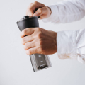 Hario Ceramic Coffee Mill Mini-Slim Plus in einer eleganten Szene, perfekt für Kaffeeliebhaber.

