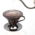 Hario Cafeor Dripper 02 pendant la préparation du café avec de l'eau chaude, directement sur une tasse.


