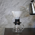 Filtres en papier Hario V60 03 Blanc utilisés dans un dripper en verre pour une préparation précise du café.