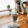 Hario Pour-Control Kettle Kasuya en train de verser de l’eau chaude avec précision sur un filtre à café.


