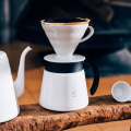 Carafe à café Hario V60 avec un dripper blanc placé au-dessus, montrant une préparation de café frais.


