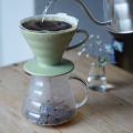 Préparation de café avec le filtre Hario V60 Smokey Green et un verseur d'eau chaude.


