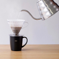 Hario heat retention mug black with V60 dripper and gooseneck kettle during coffee brewing