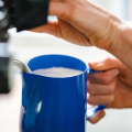 Barista bereitet Latte Art zu mit dem Rhinowares Milchkännchen 360ml.