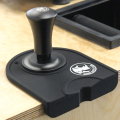 Base plate du tamper Rhino sur un tapis à tasser, finition noire.


