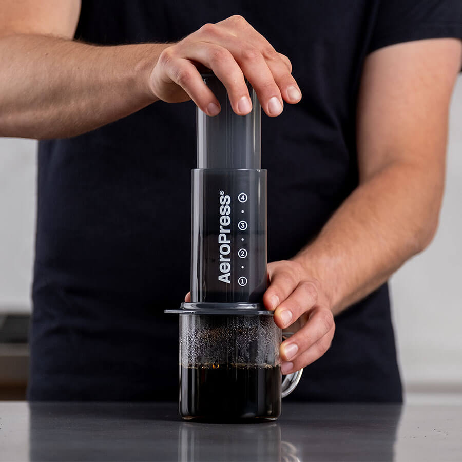 Person bereitet mit der AeroPress aromatischen Kaffee ohne Strom zu – ideal für Vanlife, Camping und unterwegs.