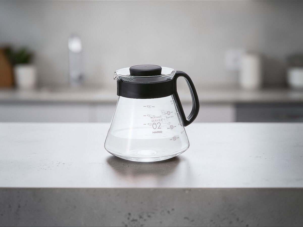 Hario V60 Range Server 600 ml glass coffee server with black handle and lid on modern kitchen countertop