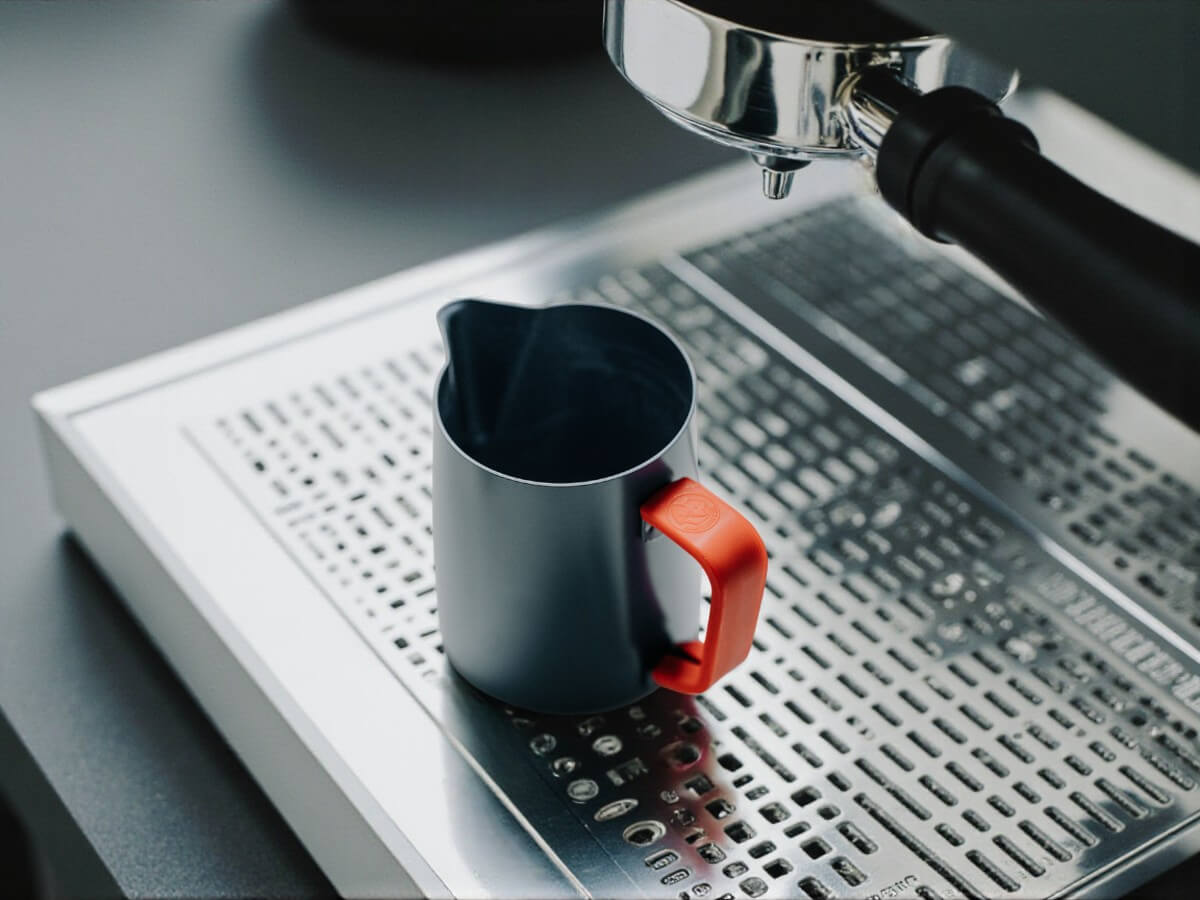 Rhino Red Silikon Griffüberzug 12oz an Milchkännchen auf Abtropfgitter einer Espressomaschine